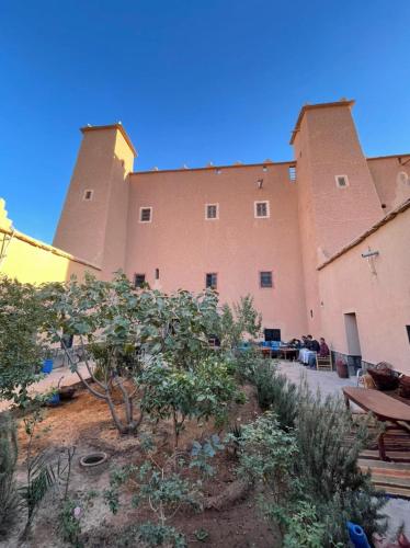 a large building with a lot of plants in front of it at La perle de saghro in Nkob