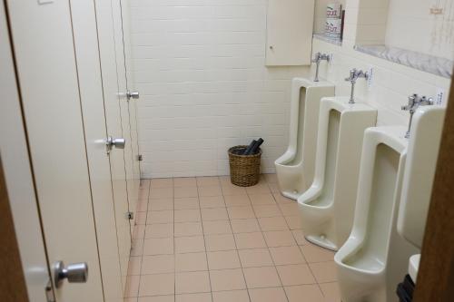 two urinals in a bathroom with three urinals at Hinodeya in Ito