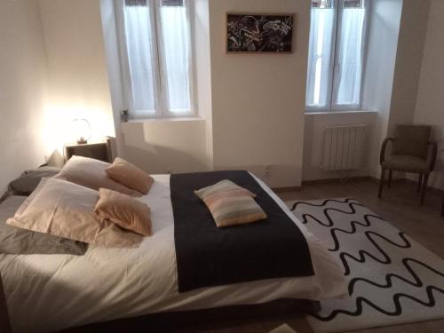 sypialnia z dużym łóżkiem z poduszkami w obiekcie Gîte de l'Oustal w mieście Oust