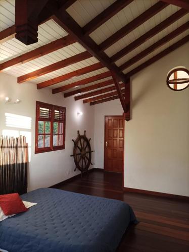 a bedroom with a blue bed and a wooden ceiling at Villa les Angélines in Dubois