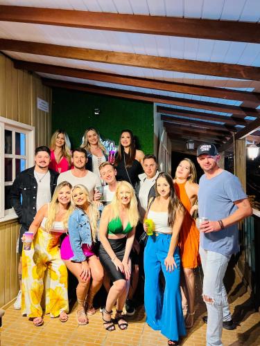 a group of people posing for a picture at a party at Pousada Rosa Center in Praia do Rosa