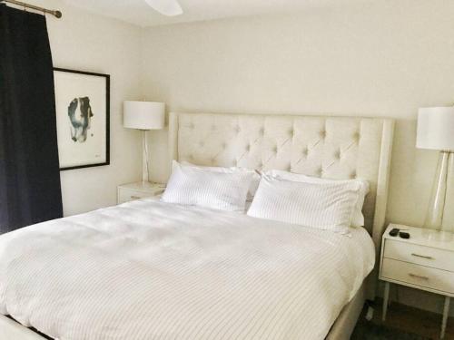 1 dormitorio con 1 cama blanca grande y 2 lámparas en Quiet, convenient & Modern Haven, en Gainesville