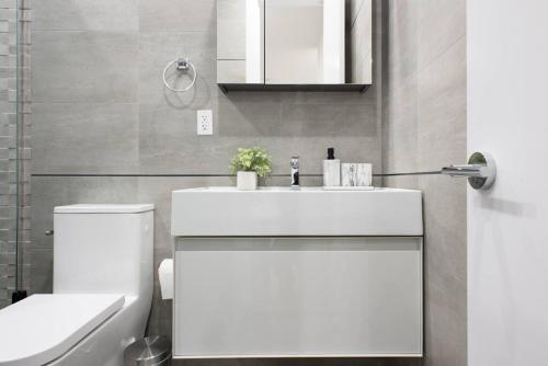 La salle de bains est pourvue d'un lavabo blanc et de toilettes. dans l'établissement 78-2B New furnished 1BR WD walk to Central Park, à New York