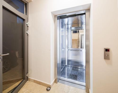 un ascenseur en verre dans une chambre avec porte dans l'établissement Apartment Prestige 1, à Trogir