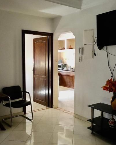 um quarto com uma porta e uma cadeira e uma cozinha em Vacances à petit prix Lot Shems em Safi