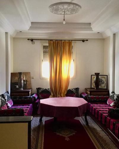 a living room with a table and couches at Vacances à petit prix Lot Shems in Safi