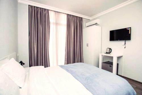 a bedroom with a bed and a large window at Astoria Sky in Tbilisi City
