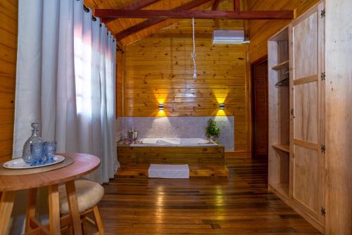 baño de madera con bañera y mesa en Fazenda Rincão Comprido Urubici, en Urubici