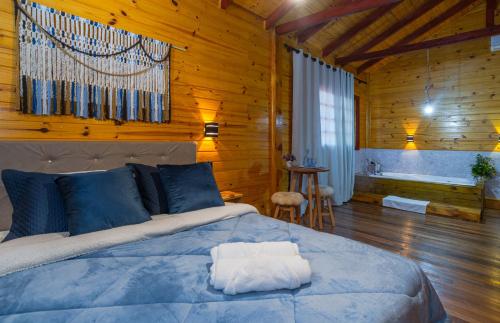 1 dormitorio con 1 cama en una cabaña de madera en Fazenda Rincão Comprido Urubici, en Urubici