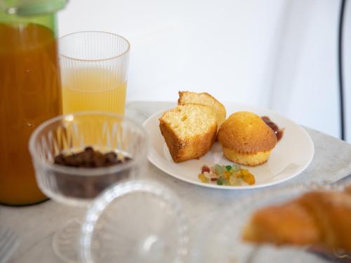 un tavolo con un piatto di cibo e un bicchiere di succo d'arancia di Salotto Borbonico a Napoli