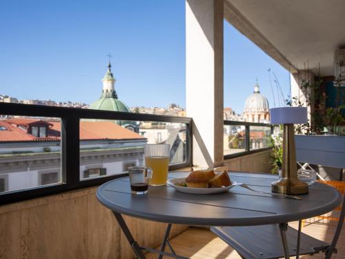 una mesa con un plato de comida y bebida en el balcón en Salotto Borbonico, en Nápoles