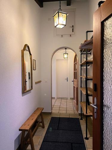 a hallway with a wooden bench and a mirror at Casa Campanula in Laax