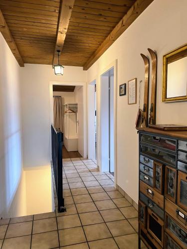 a hallway with a tile floor and a wooden ceiling at Casa Campanula in Laax