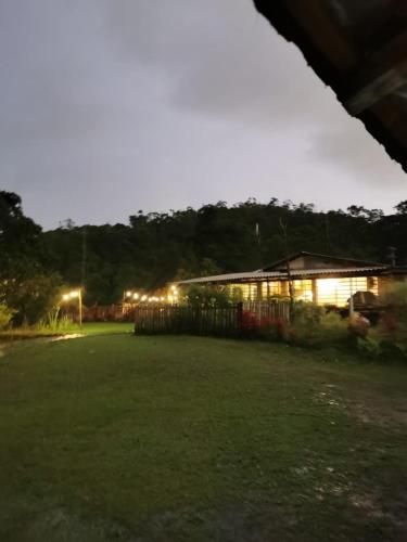 a building with lights in a field at night at Lago 7 Cores in Tapiraí
