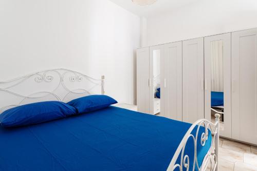une chambre avec un lit bleu et blanc avec des oreillers bleus dans l'établissement Appartamento climatizzato a 50 m dal mare nel centro di Torre San Giovanni, à Torre San Giovanni