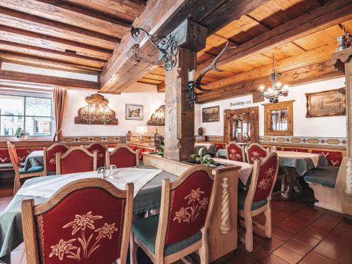 ein Restaurant mit Tischen und Stühlen in einem Zimmer mit Holzdecken in der Unterkunft Hotel Mitterhof in Gerlos