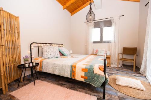 a bedroom with a bed and a chair and a window at Stellas guesthouse near Arachova in Stírion