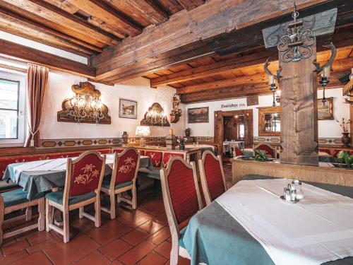 a restaurant with tables and chairs and wooden ceilings at Hotel Mitterhof in Gerlos