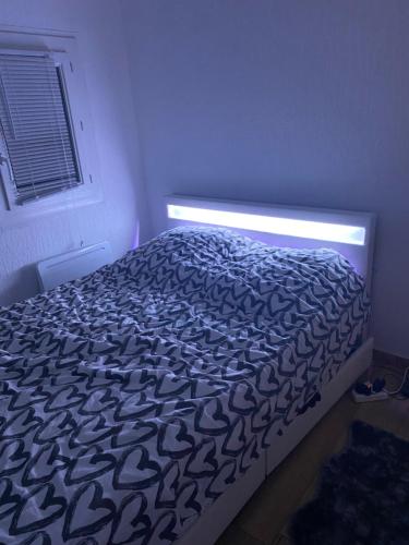 - un lit dans une chambre éclairée dans l'établissement Appartement cozy, à Montpellier