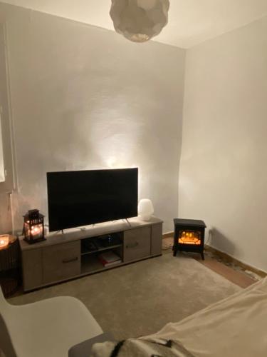 uma sala de estar com uma televisão de ecrã plano e uma lareira em Appartement cozy em Montpellier