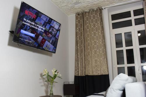 a living room with a flat screen tv on the wall at AmazINN Places Rooftop and Jacuzzi I in Panama City