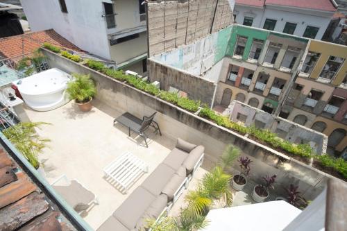 a view of a patio with chairs and plants on a building at AmazINN Places Rooftop and Jacuzzi I in Panama City