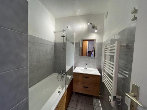 uma casa de banho com uma banheira, um lavatório e um chuveiro em Appartement Lanslevillard, 2 pièces, 4 personnes - FR-1-508-23 em Lanslevillard