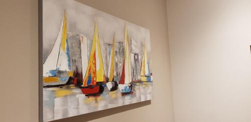 a painting of sailboats hanging on a wall at AppPrusnik in Ljubljana