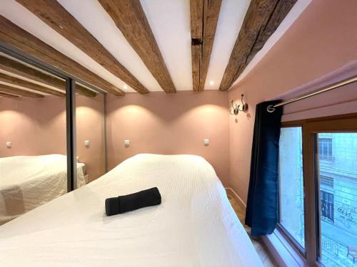 een slaapkamer met een wit bed en een raam bij Logement de charme avec balnéo in Lyon