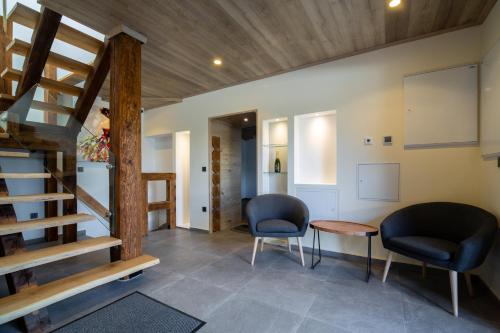 a living room with two chairs and a staircase at AppPrusnik in Ljubljana