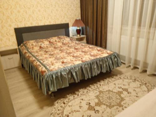 ein Schlafzimmer mit einem Bett und einem Teppich in der Unterkunft Посуточная аренда жилья in Mohyliv-Podilʼsʼkyy