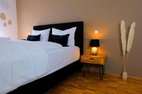 um quarto com uma cama e uma mesa de cabeceira com um candeeiro em Design Apartment Nr 1 mit Terrasse und Parkplatz em Straubing