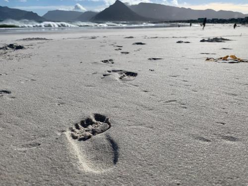 a pair of footprints in the sand on a beach at Rest@Kommetjie in Cape Town