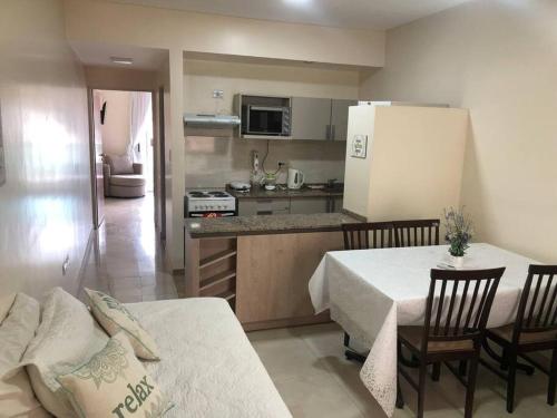 cocina y comedor con 2 mesas y refrigerador en Ultra comfy en Barrio Norte- un dormi con lavarrop en San Miguel de Tucumán