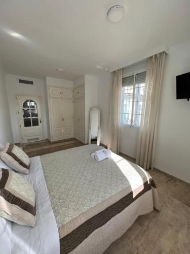 a bedroom with two beds and a flat screen tv at ATICO SUITE CLAUDIO MARCELO in Córdoba