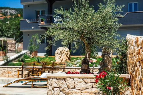 a garden with a tree and benches and a building at VILLA G., Relaxing and Unique nest of Enjoyment in Imotski