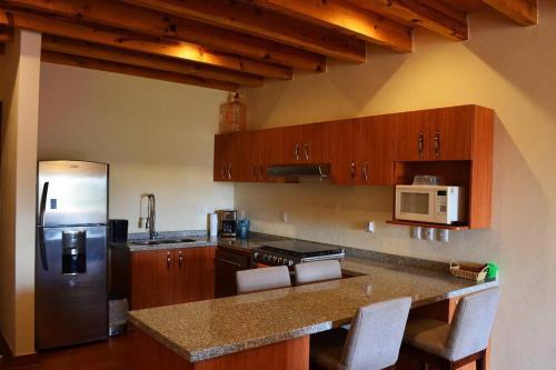 a kitchen with a refrigerator and a counter top at Beautiful home w/Pool @Capilla de Piedra in San Miguel de Allende