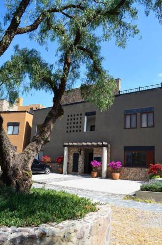 a building with a tree in front of it at Beautiful home w/Pool @Capilla de Piedra in San Miguel de Allende