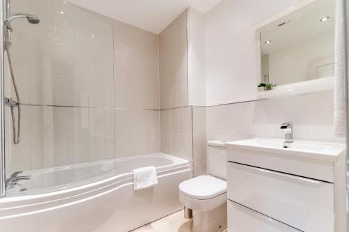 e bagno bianco con vasca, servizi igienici e lavandino. di MODERN HOUSE near the CITY CENTRE a Peterborough