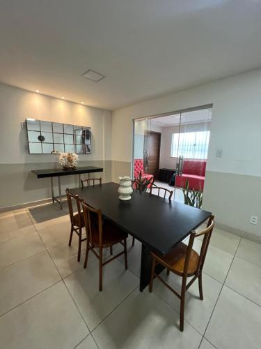 uma cozinha e sala de jantar com uma mesa preta e cadeiras em Hangar House em Belém