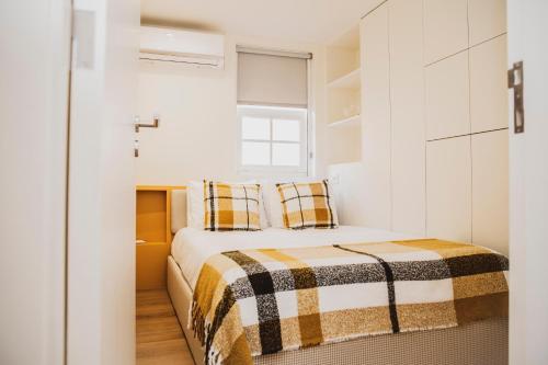 a small bedroom with a bed and a window at Casa de Couros in Guimarães