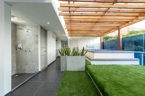 a bathroom with a shower and green grass at Piedra Luna in Cali