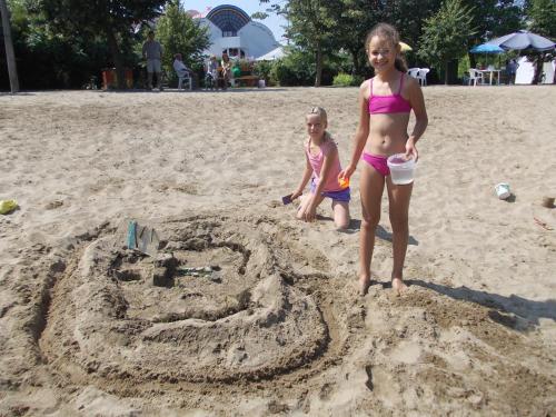 a girl and a little girl standing in the sand at Hőforrás Hotel in Gyula