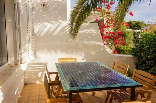 una mesa y sillas en un patio con flores en Three bedroom house by the sea, en Agua Amarga