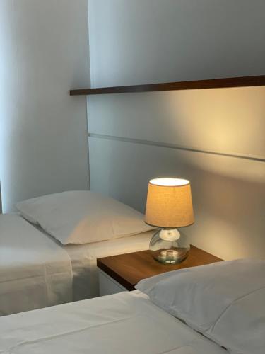 1 dormitorio con 2 camas y una lámpara en una mesa en Villa Dei Fiori en São Sebastião