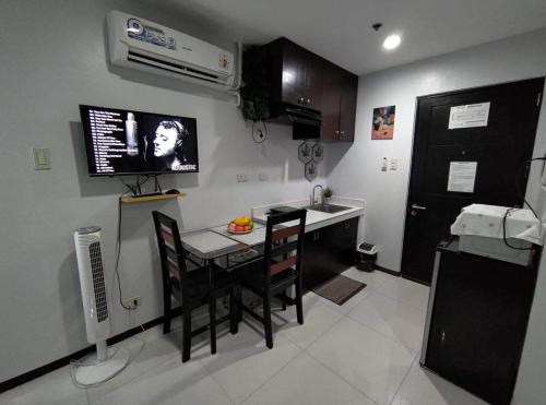 cocina con mesa, sillas y fregadero en Simply Comfy 916 (Cityscape Bacolod) en Bacolod
