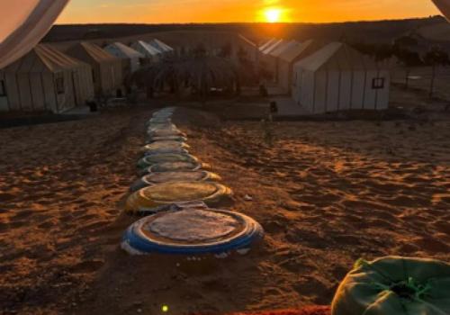 a row of frisbees on the beach at sunset at Merzouga best camp in Merzouga