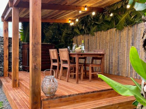 a wooden deck with a table and chairs on it at Azores Bagus Surf House in Ponta Delgada