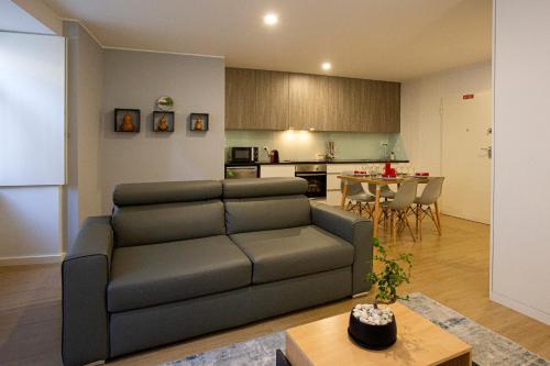uma sala de estar com um sofá e uma cozinha em Apartamento C&C em Arcos de Valdevez