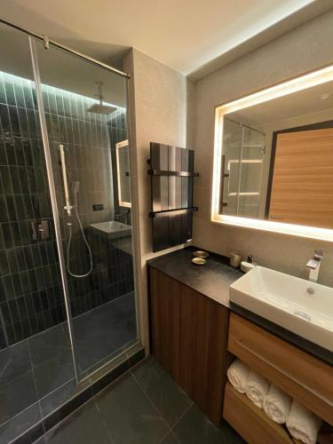 a bathroom with a shower and a sink and a mirror at Apartman Kopaonik Woodside 106 in Kopaonik